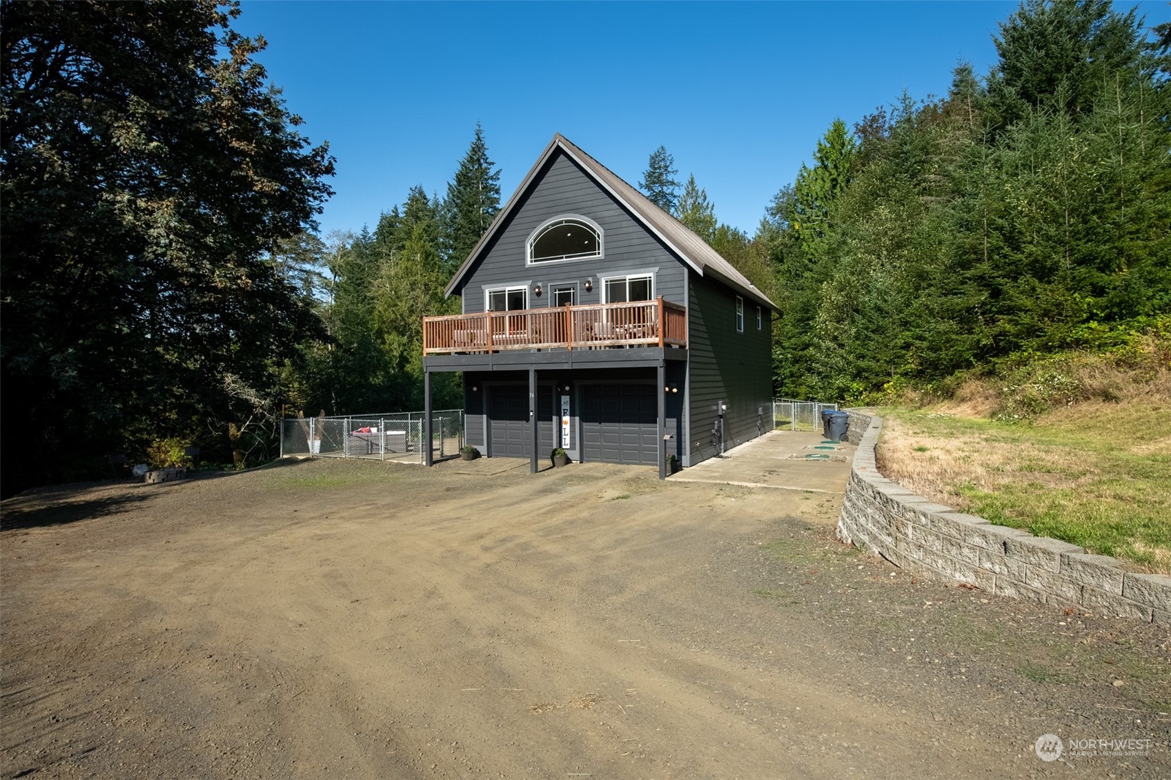 a front view of house with yard and trees in the background