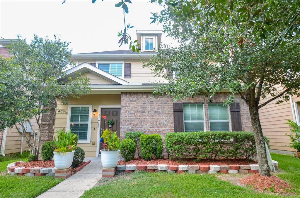 a front view of a house with a yard and potted plants