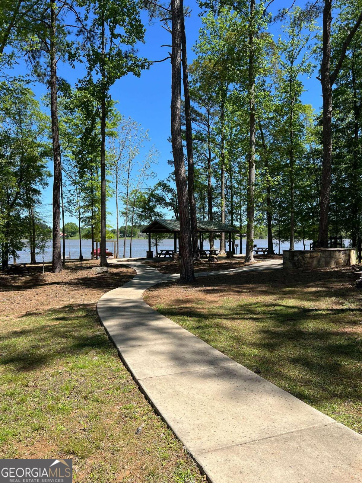 a view of swimming pool with outdoor seating and trees in the background