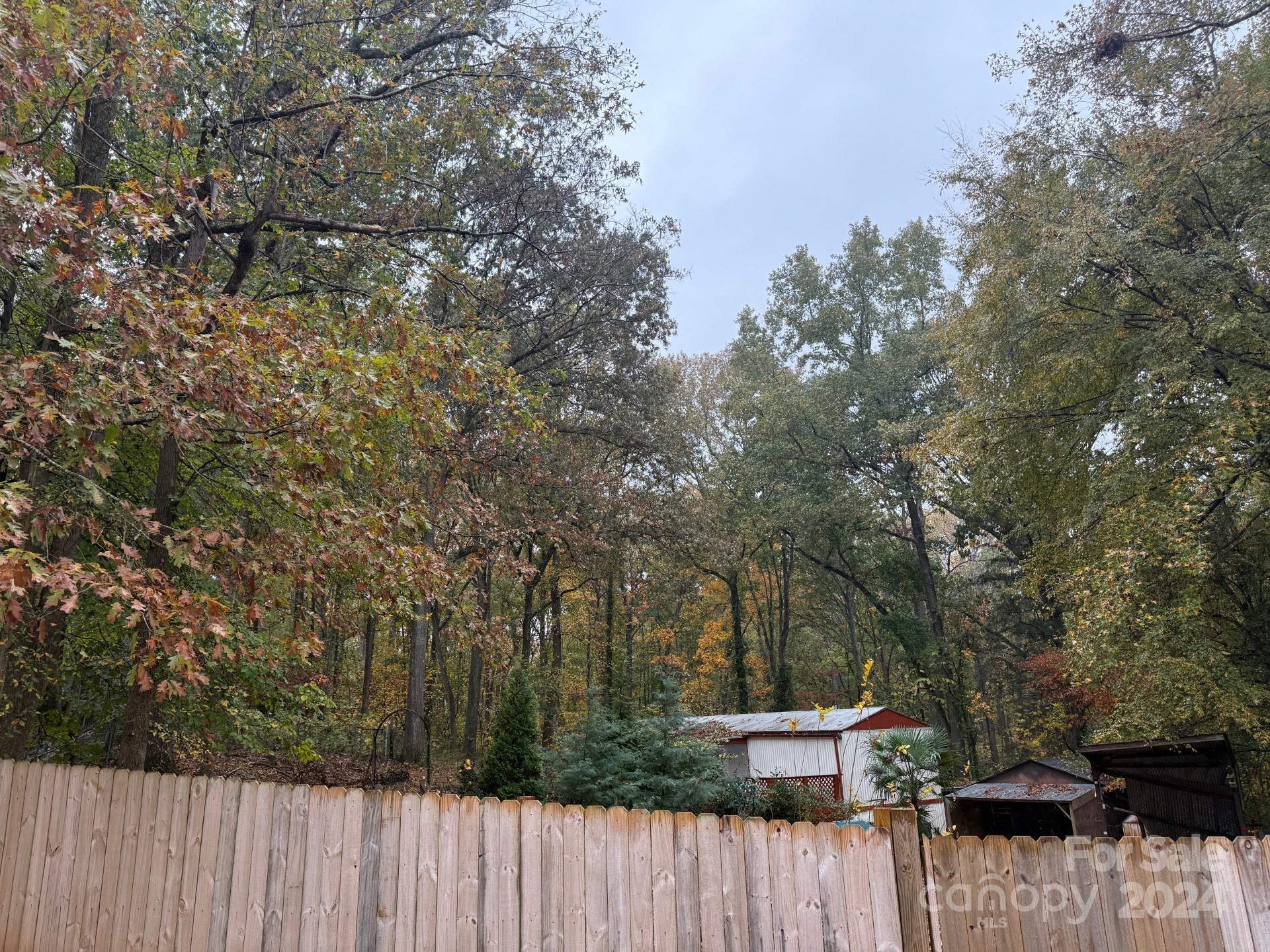 a view of a wooden fence and trees