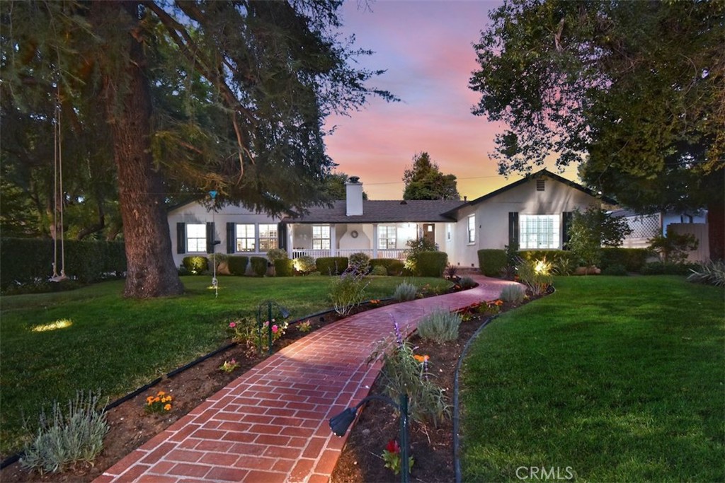 a front view of a house with yard and green space