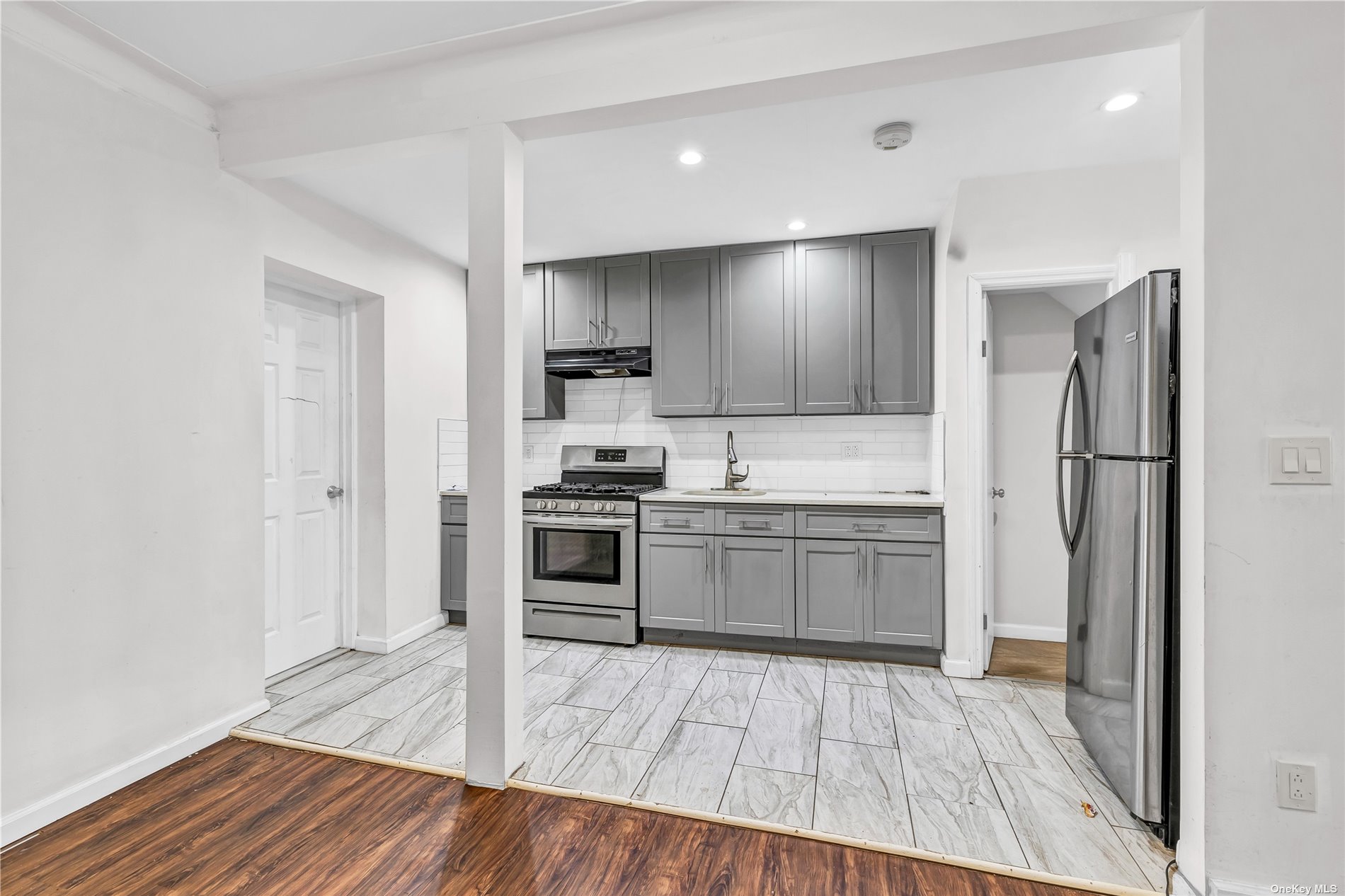 a kitchen with a refrigerator and a stove top oven