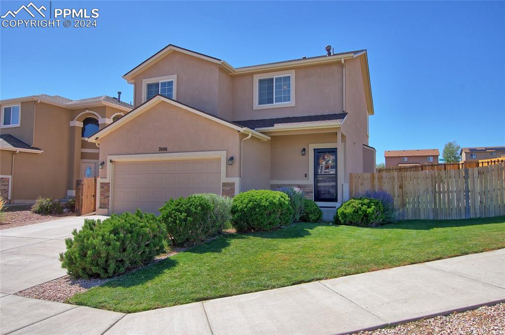 View of front of house with a front yard and a garage