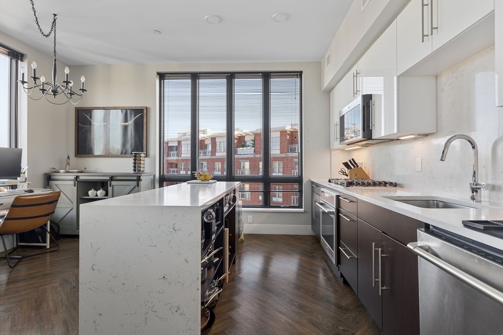 a kitchen with sink a refrigerator and chairs