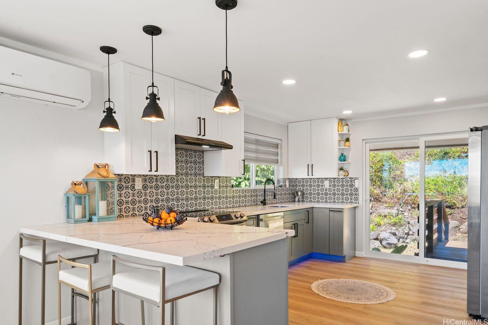 a kitchen with a stove a sink a window and chairs