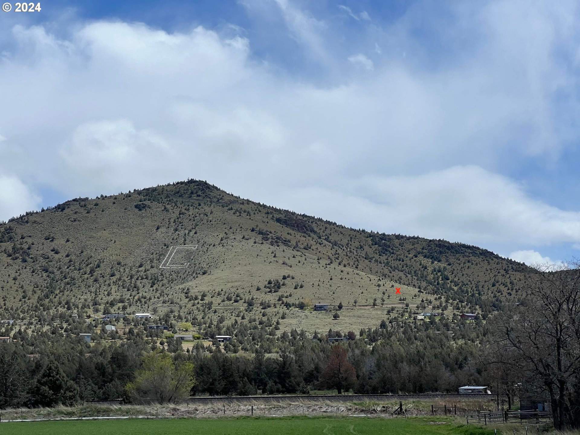 a view of a big yard with mountains in the background