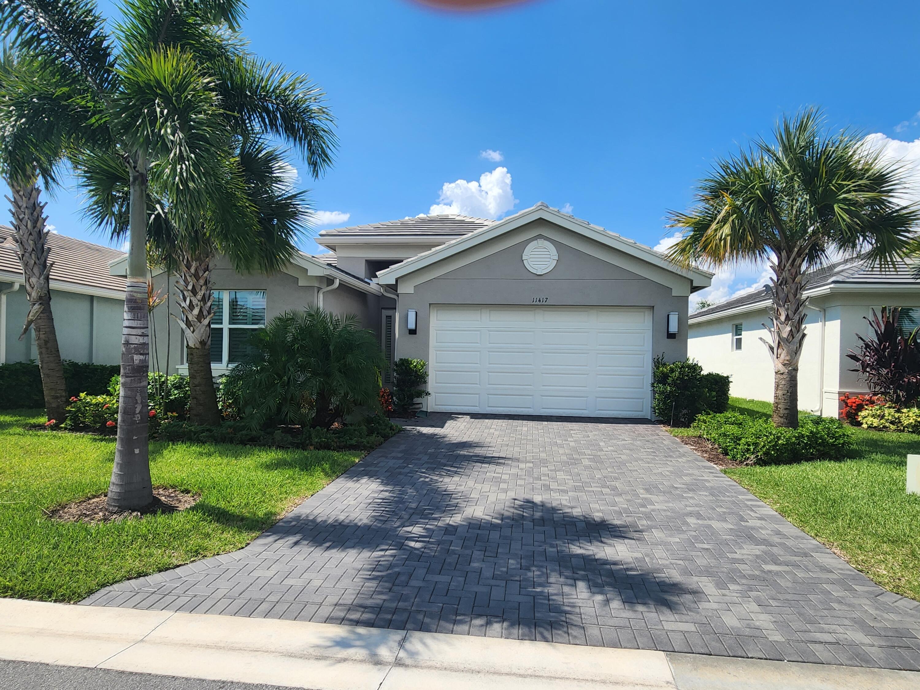 a front view of a house with a yard and a garage