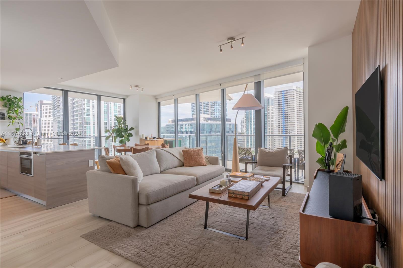 a living room with furniture a flat screen tv and a large window