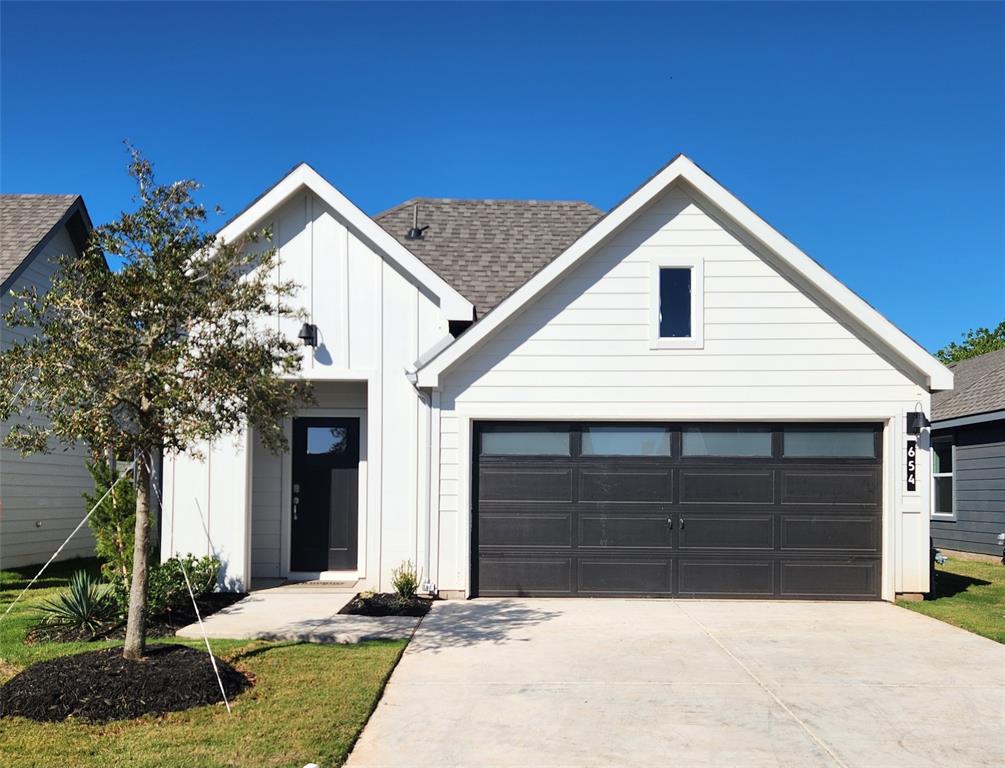 a view of house with yard and garage