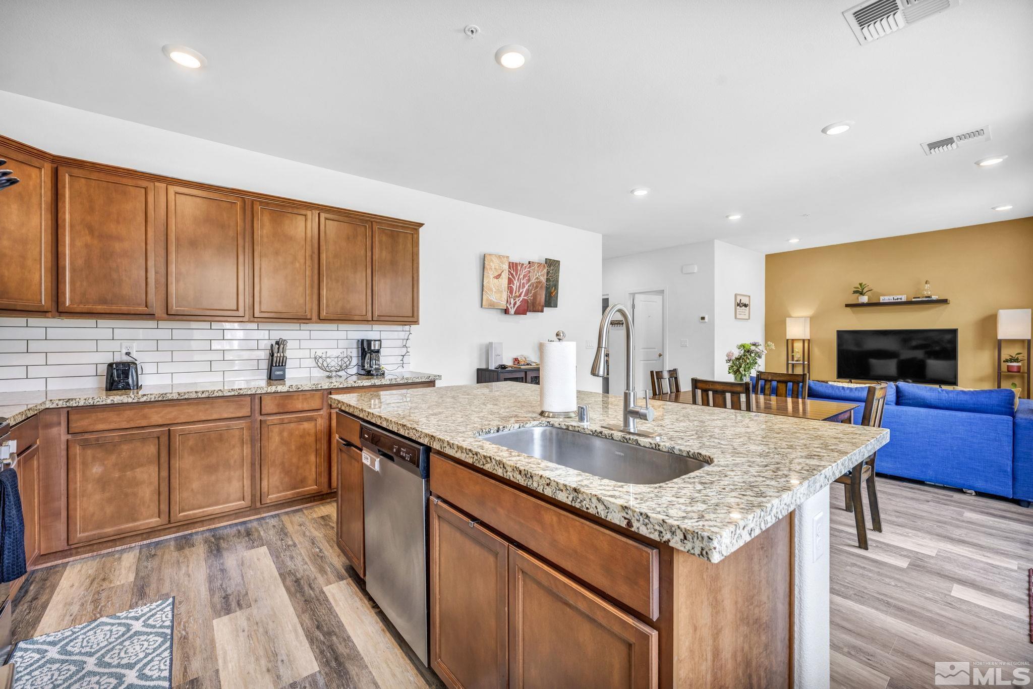 a kitchen with stainless steel appliances granite countertop a sink stove and cabinets