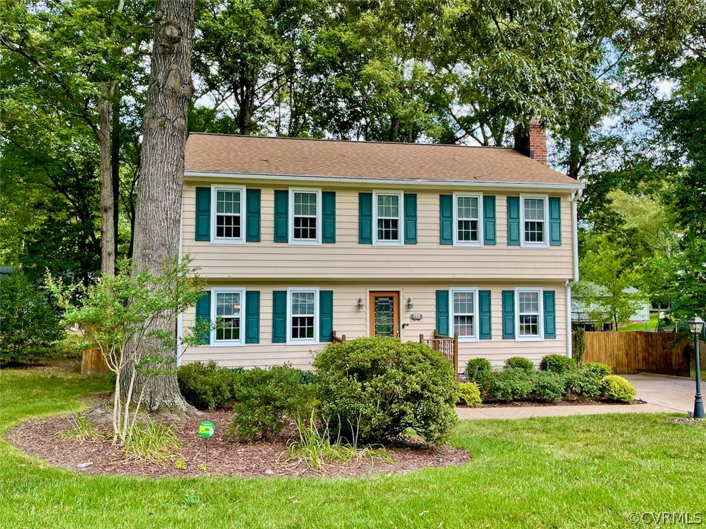 Colonial home featuring a front lawn