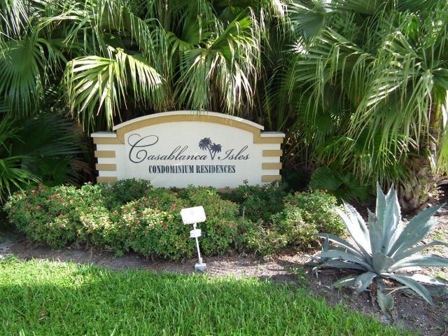 a sign that is sitting in front of a big yard with plants