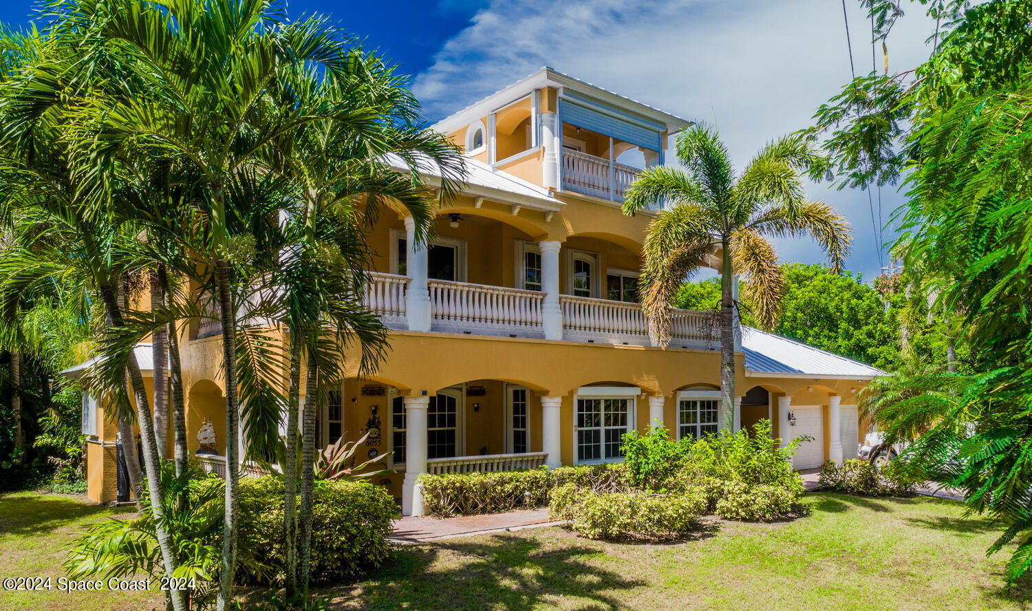 a front view of a house with a yard and potted plants