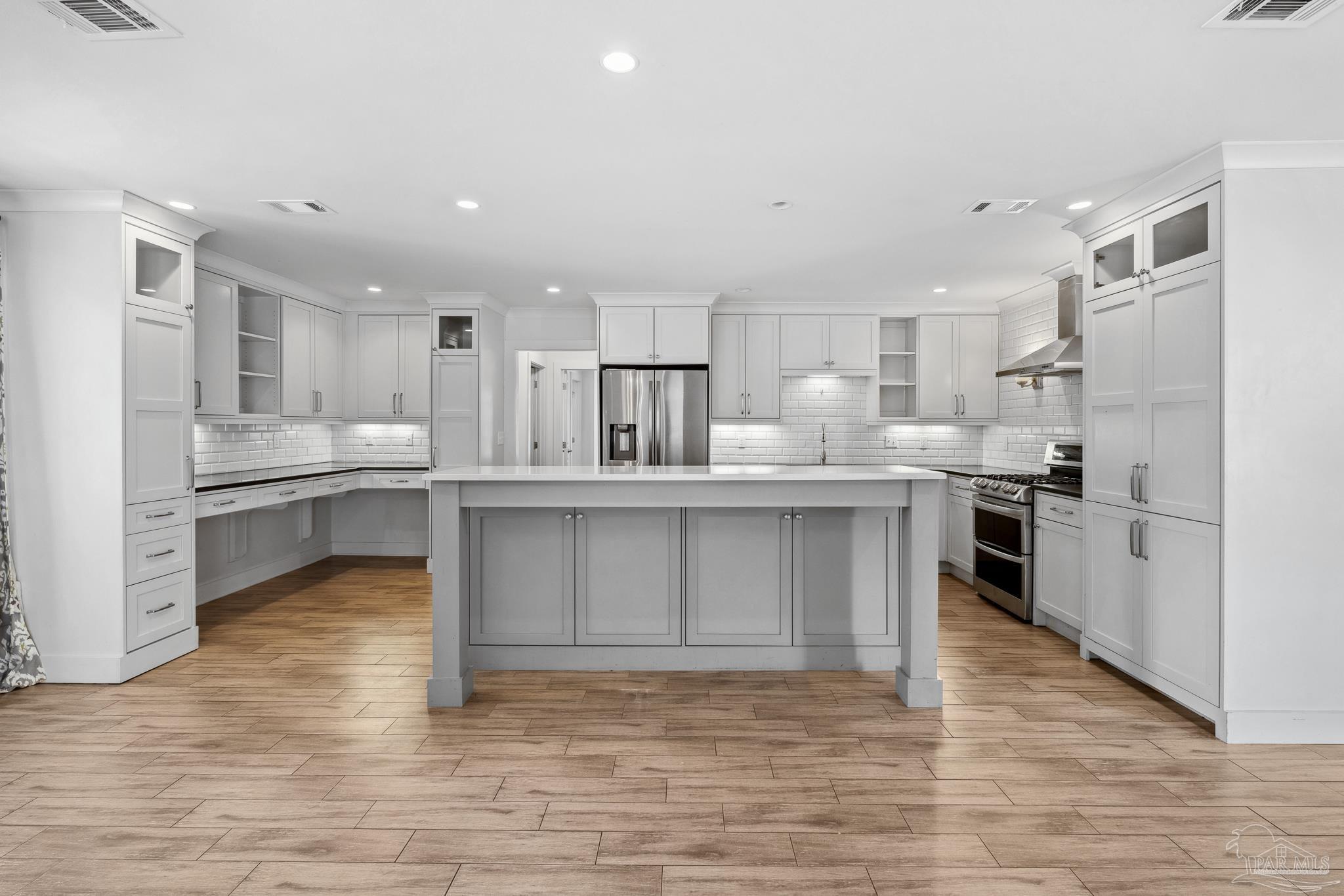 a kitchen with kitchen island a sink stainless steel appliances and cabinets