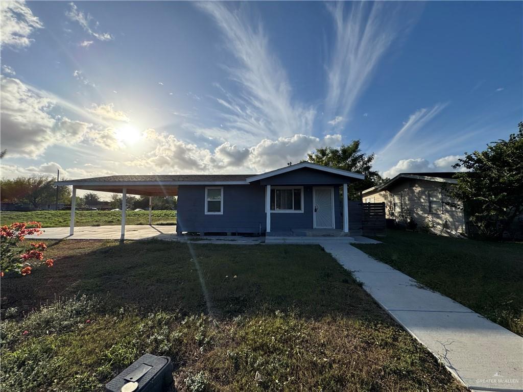 View of front of home featuring a carport and a front yard