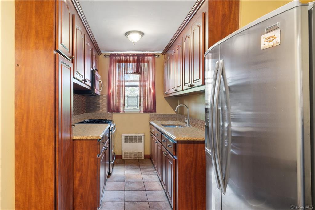 a kitchen with stainless steel appliances granite countertop a refrigerator a sink and a stove