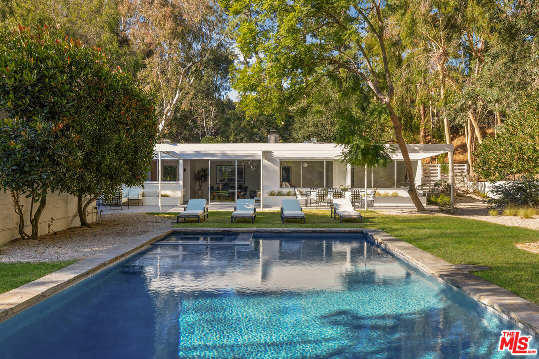 a view of house with backyard and sitting area