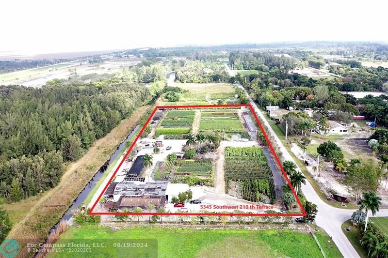 an aerial view of residential houses with outdoor space and trees