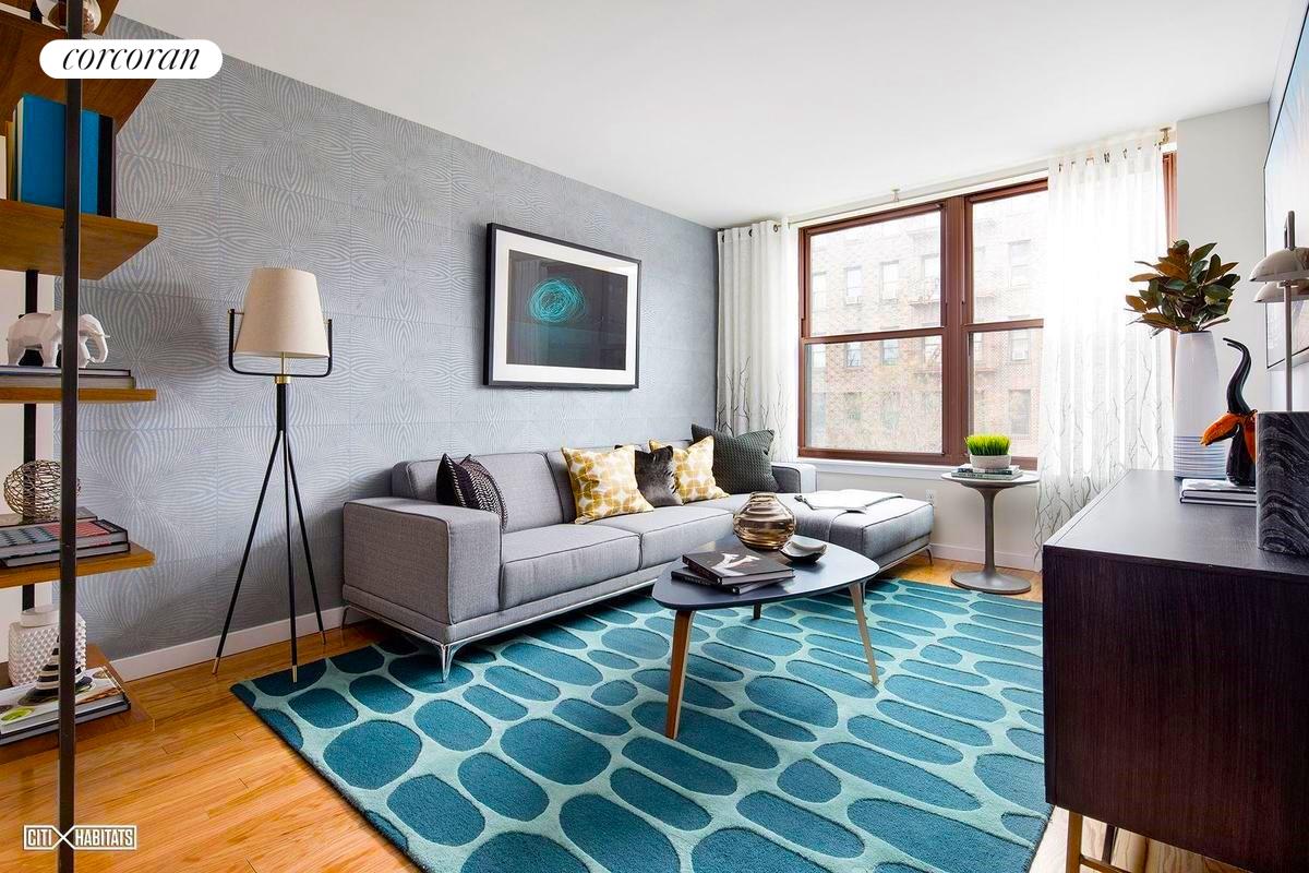 a living room with furniture a rug and a floor to ceiling window