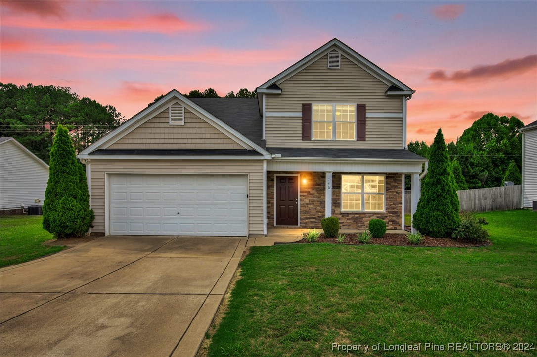 a front view of a house with a yard and garage