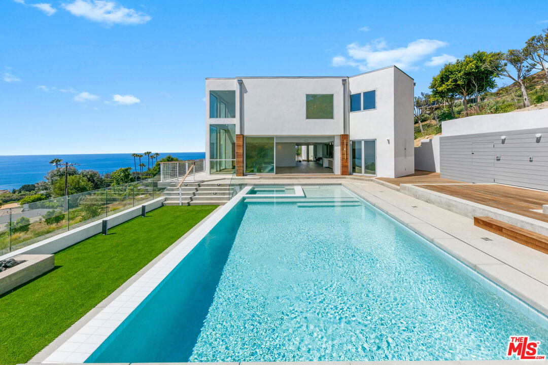 a view of an house with swimming pool and chairs