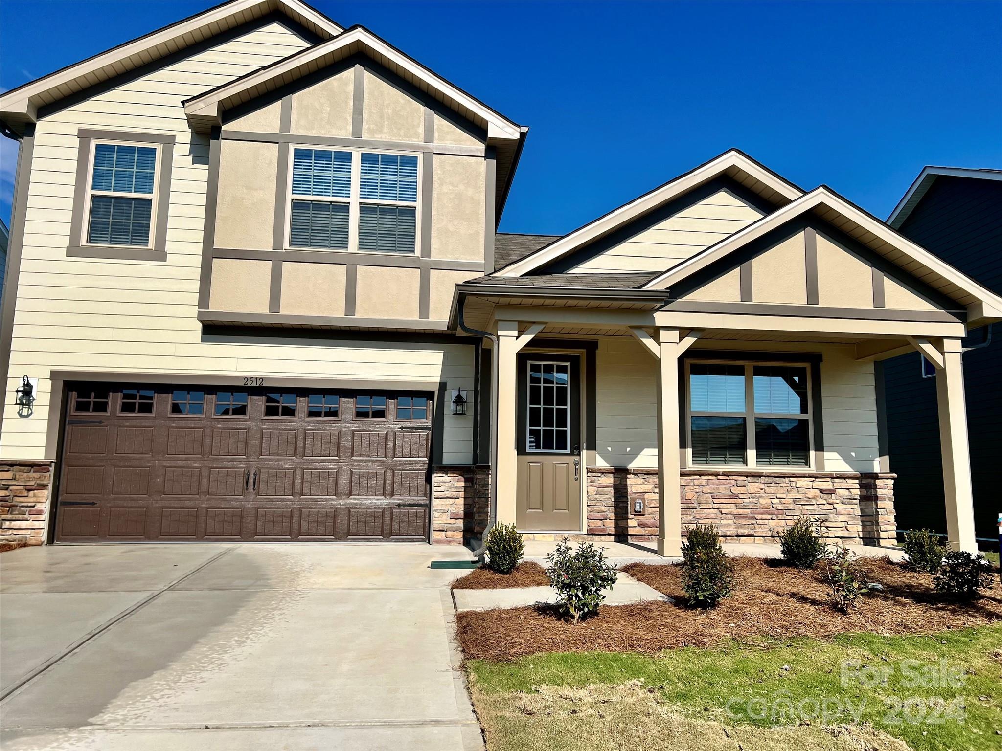 a front view of a house with a yard and garage