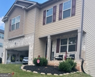 a view of a house with a yard and sitting area