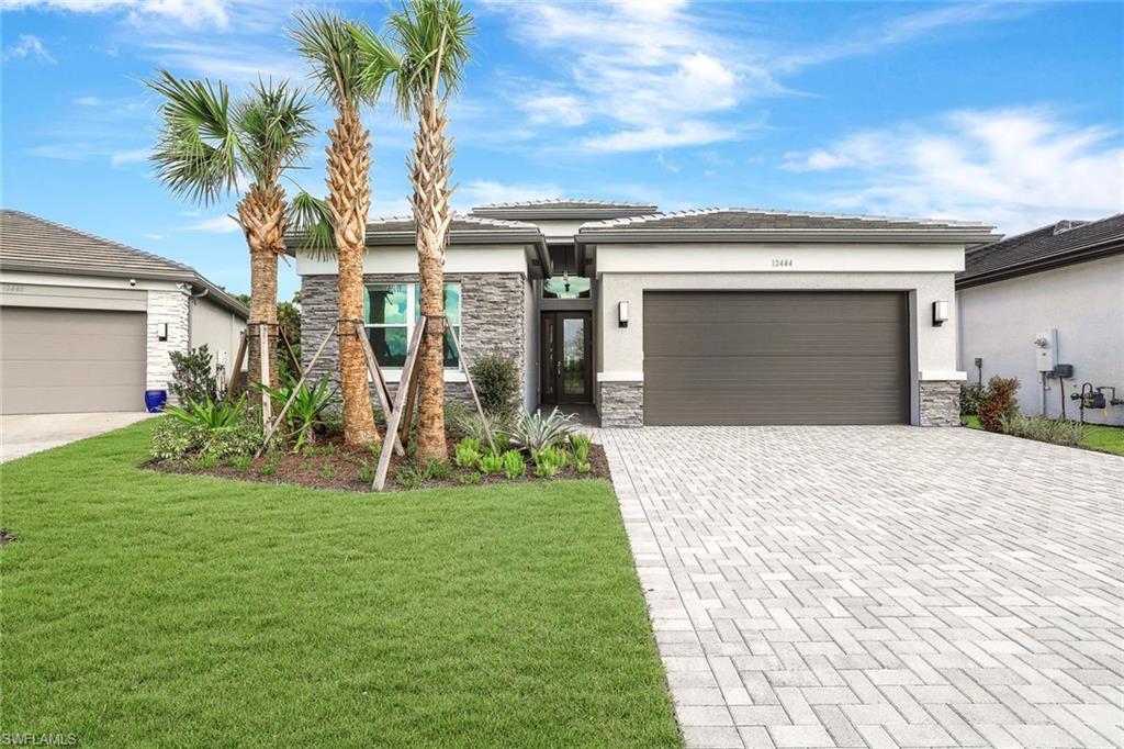 a front view of a house with a yard and garage