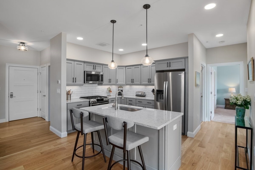 a kitchen with stainless steel appliances kitchen island a refrigerator and a stove top oven