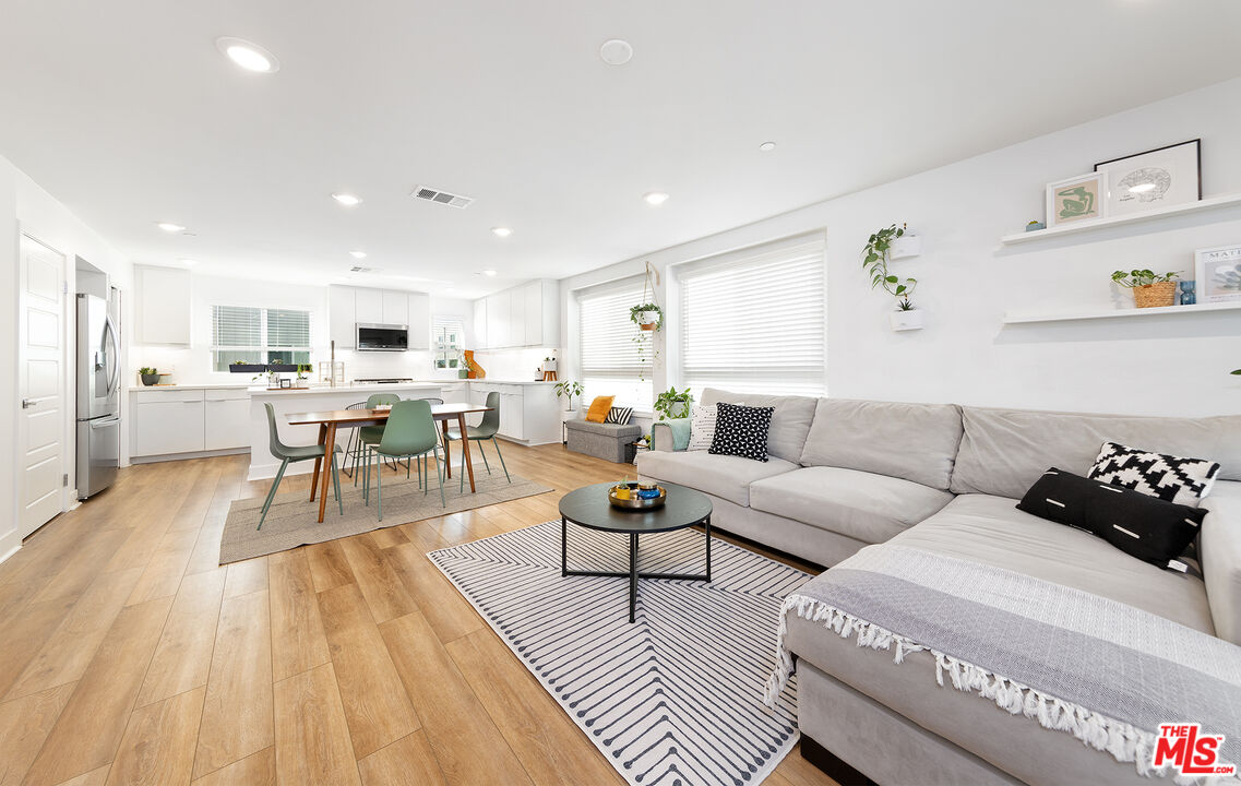 a living room with furniture and view of kitchen