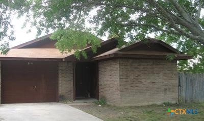 a front view of a house with a tree