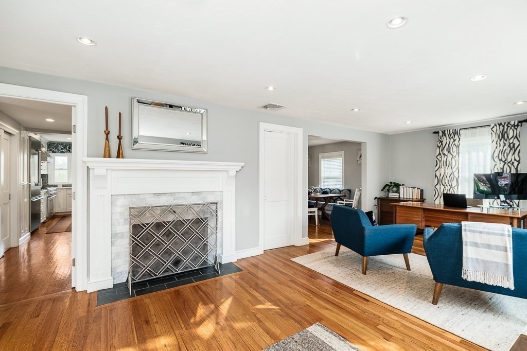 a living room with furniture a fireplace and wooden floor