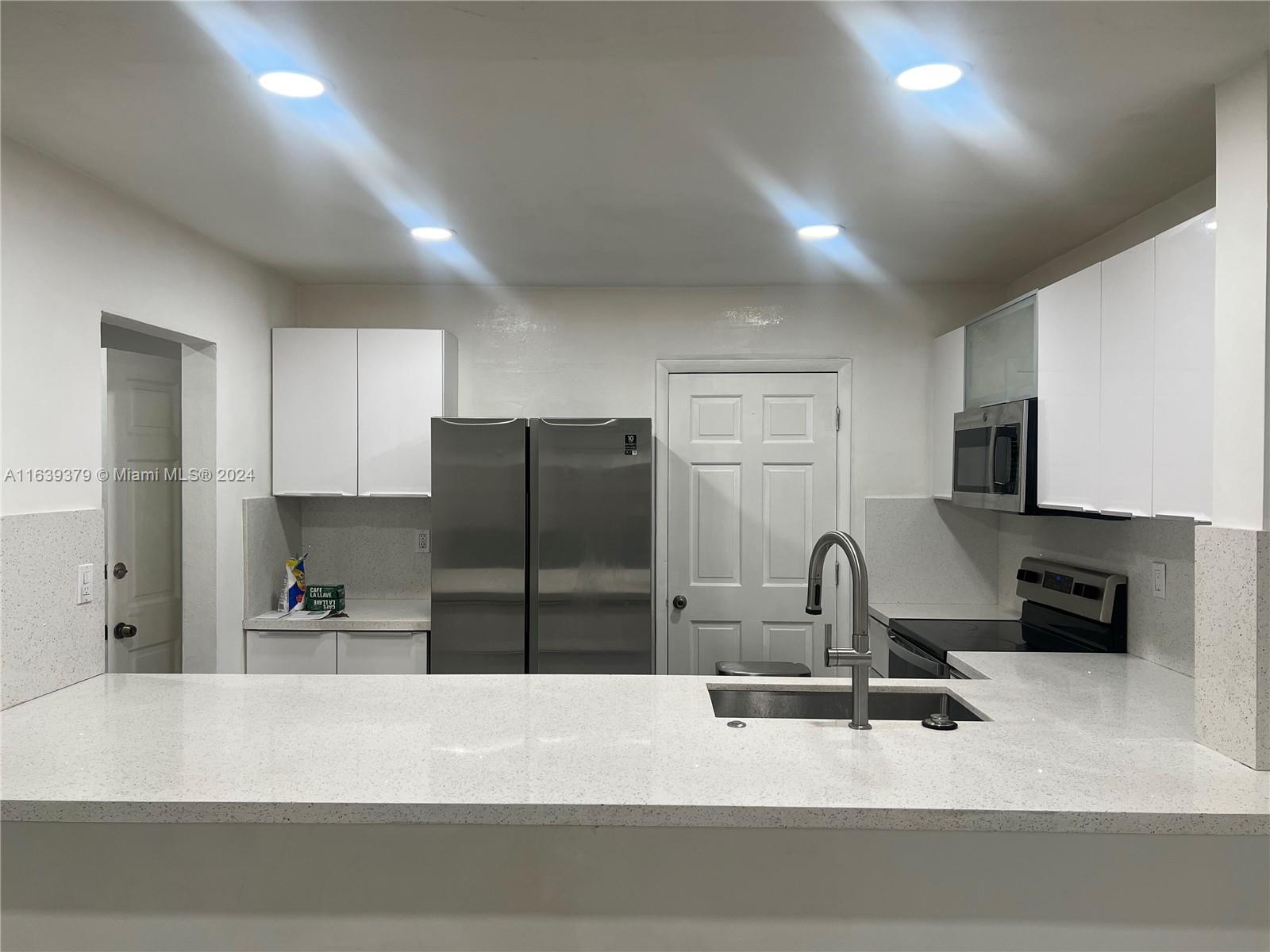 a kitchen with a refrigerator and a sink