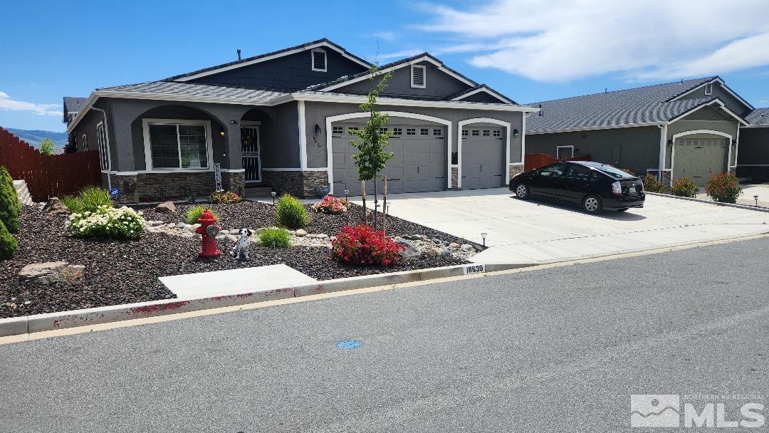 a front view of a house with a yard and potted plants