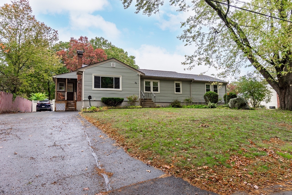 a front view of house with yard and trees around