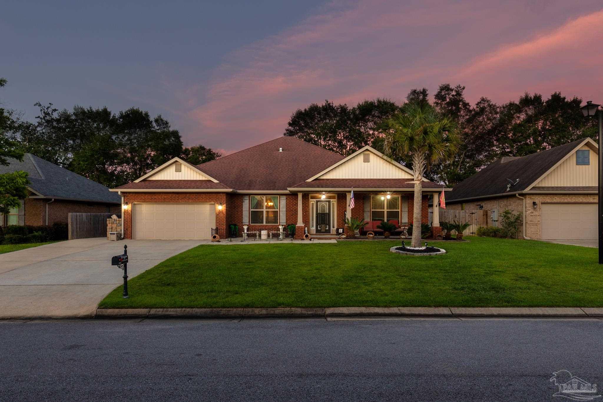 a front view of a house with a garden and yard