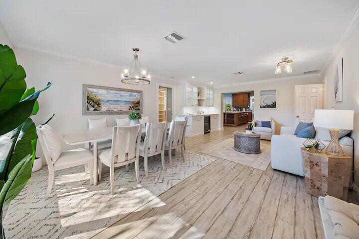 a dining room with furniture a chandelier and wooden floor