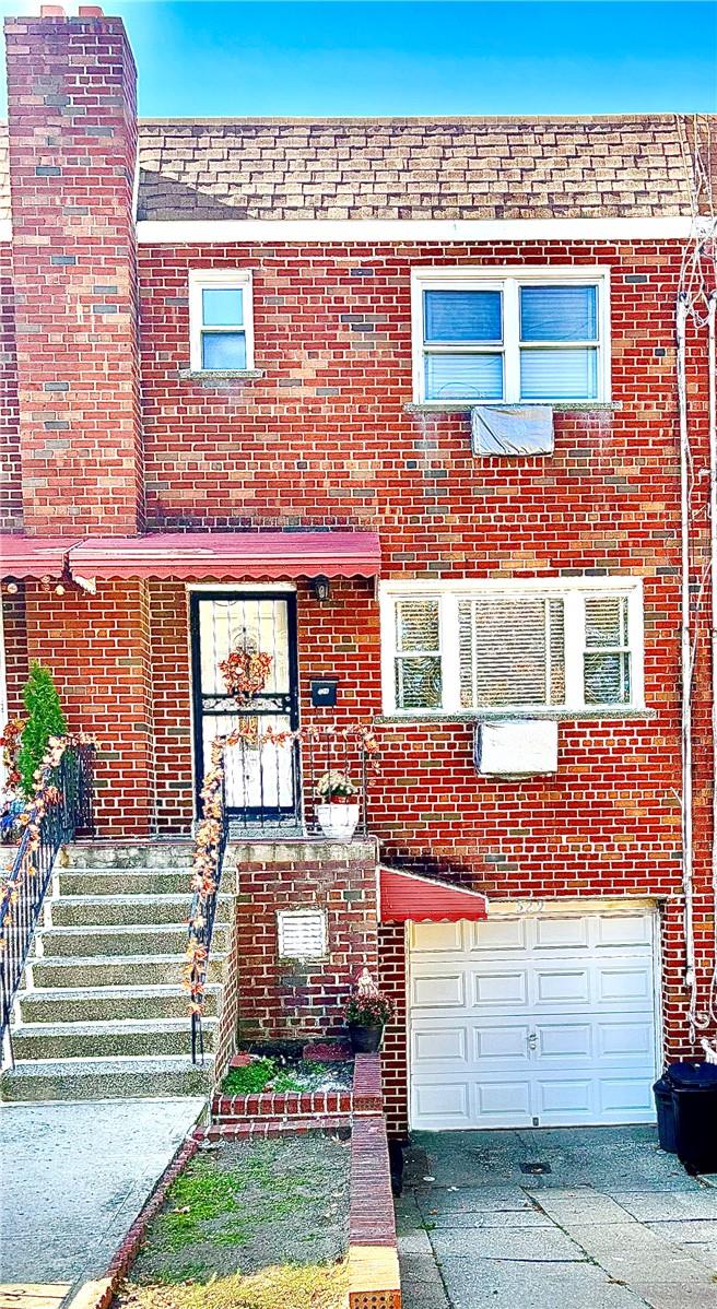 Front of Brick home featuring a Garage