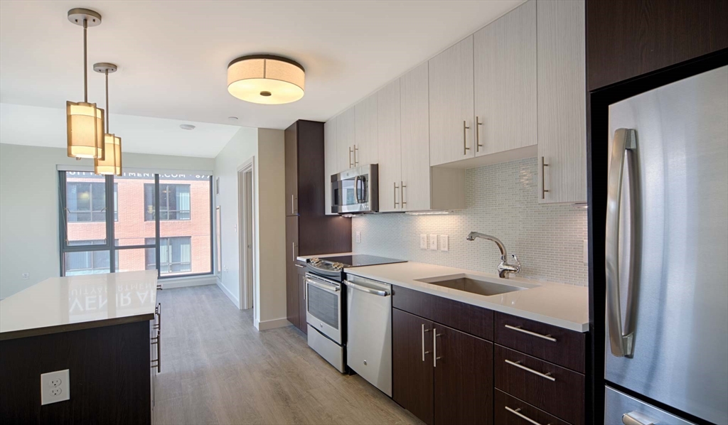 a kitchen with stainless steel appliances granite countertop a sink a stove and a refrigerator