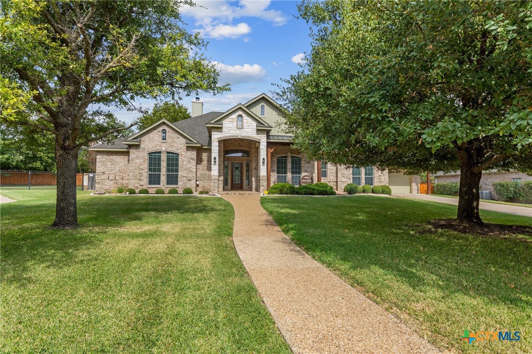 a front view of a house with yard and green space