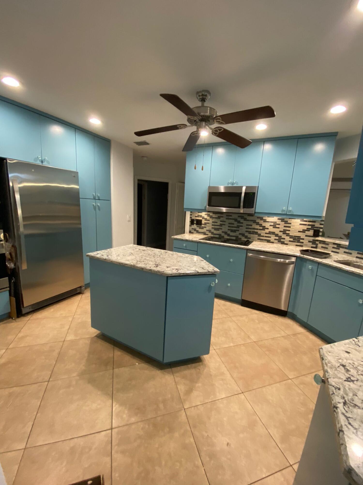 a kitchen with stainless steel appliances granite countertop a sink and a refrigerator