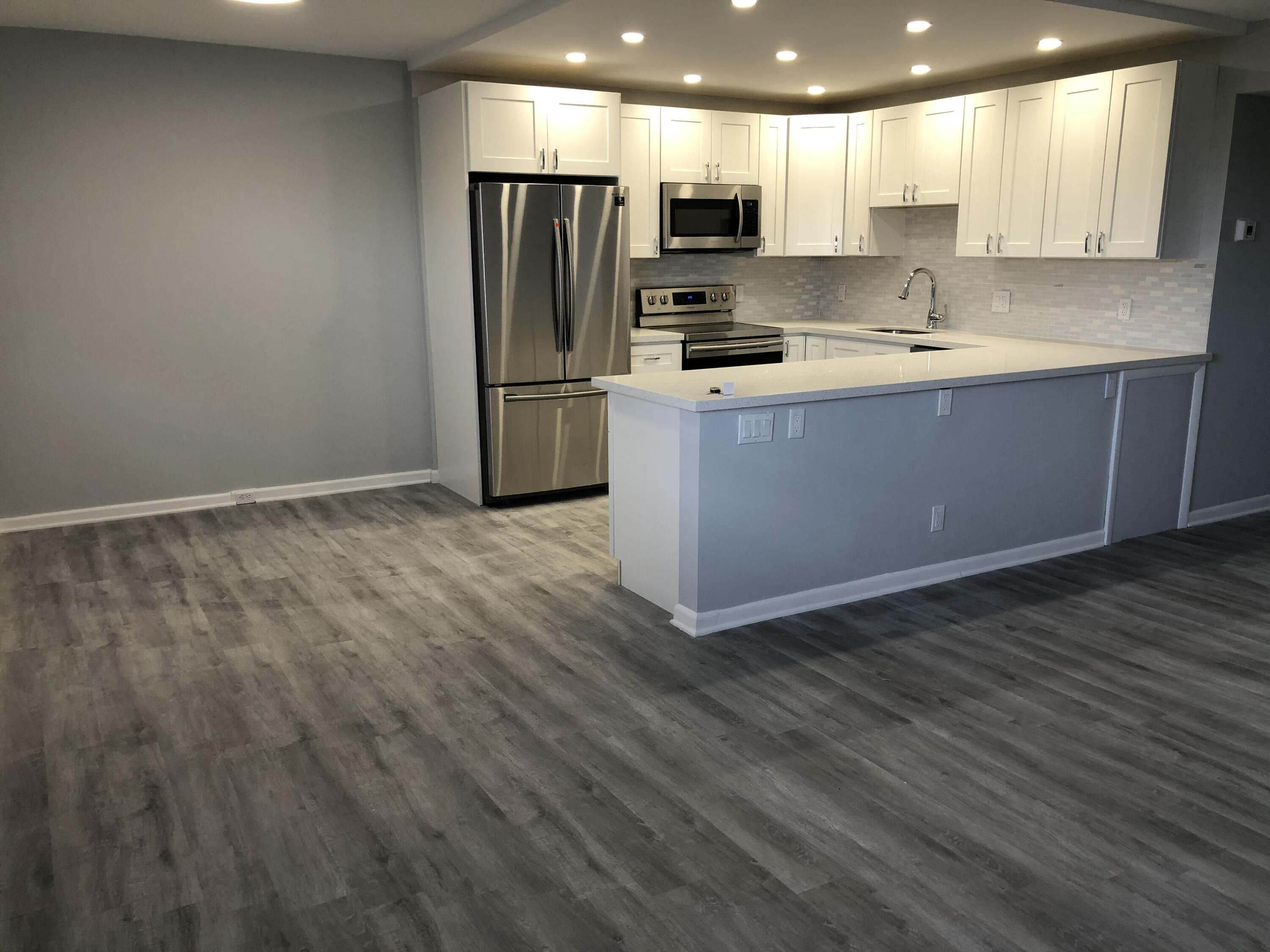 a kitchen with stainless steel appliances a refrigerator sink and microwave