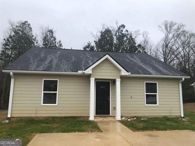 a front view of a house with yard and trees