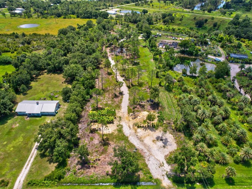 an aerial view of residential houses with outdoor space and trees all around