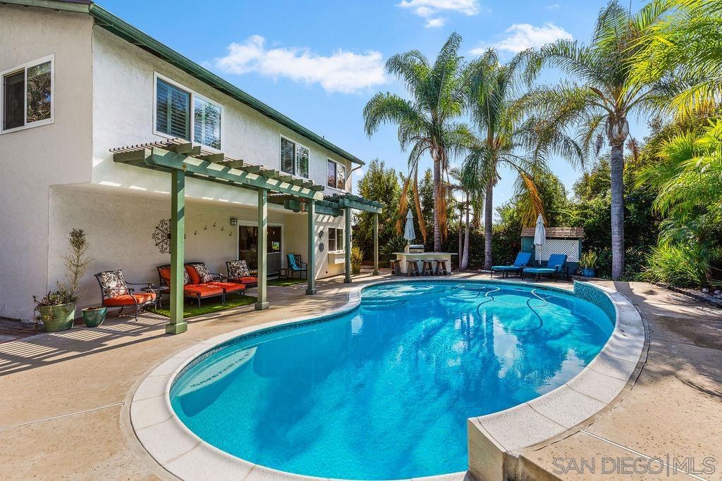 a view of a house with swimming pool and sitting area