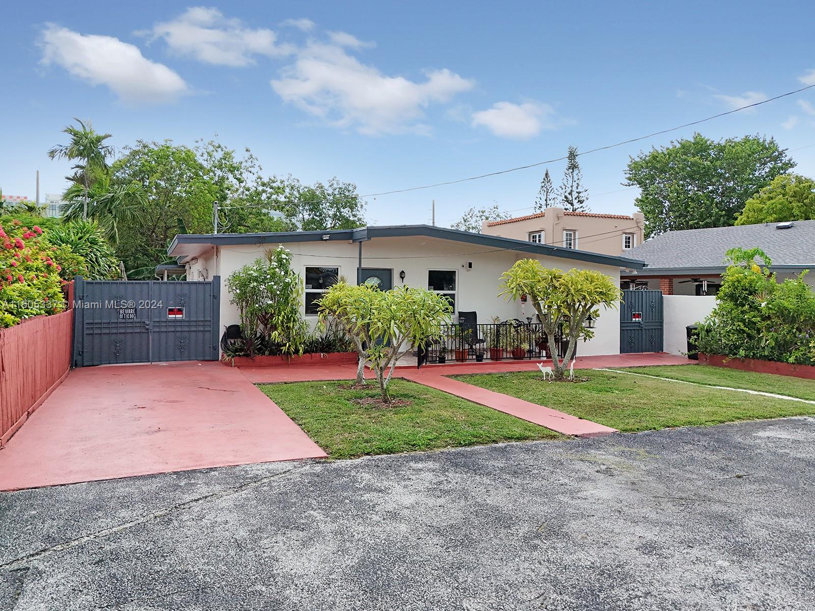 a front view of a house with a yard and potted plants