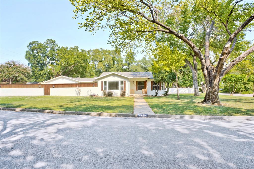 a view of house with backyard and trees