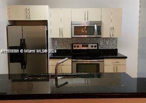 a kitchen with granite countertop a stove and a microwave