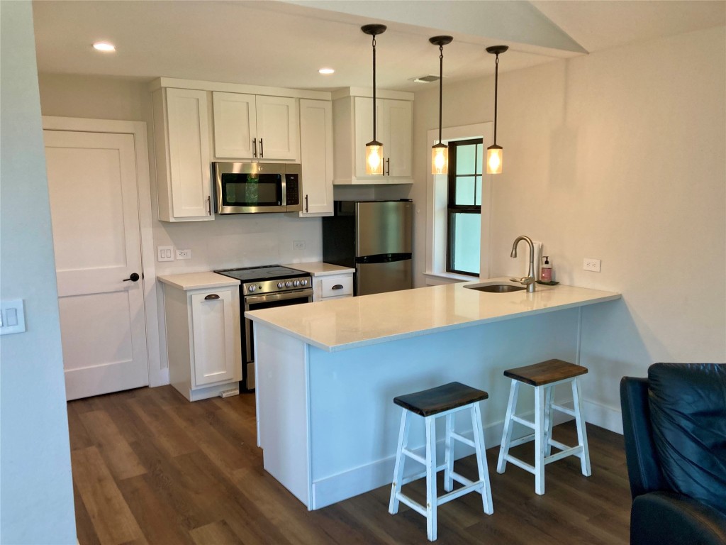 a kitchen with a table chairs refrigerator and microwave