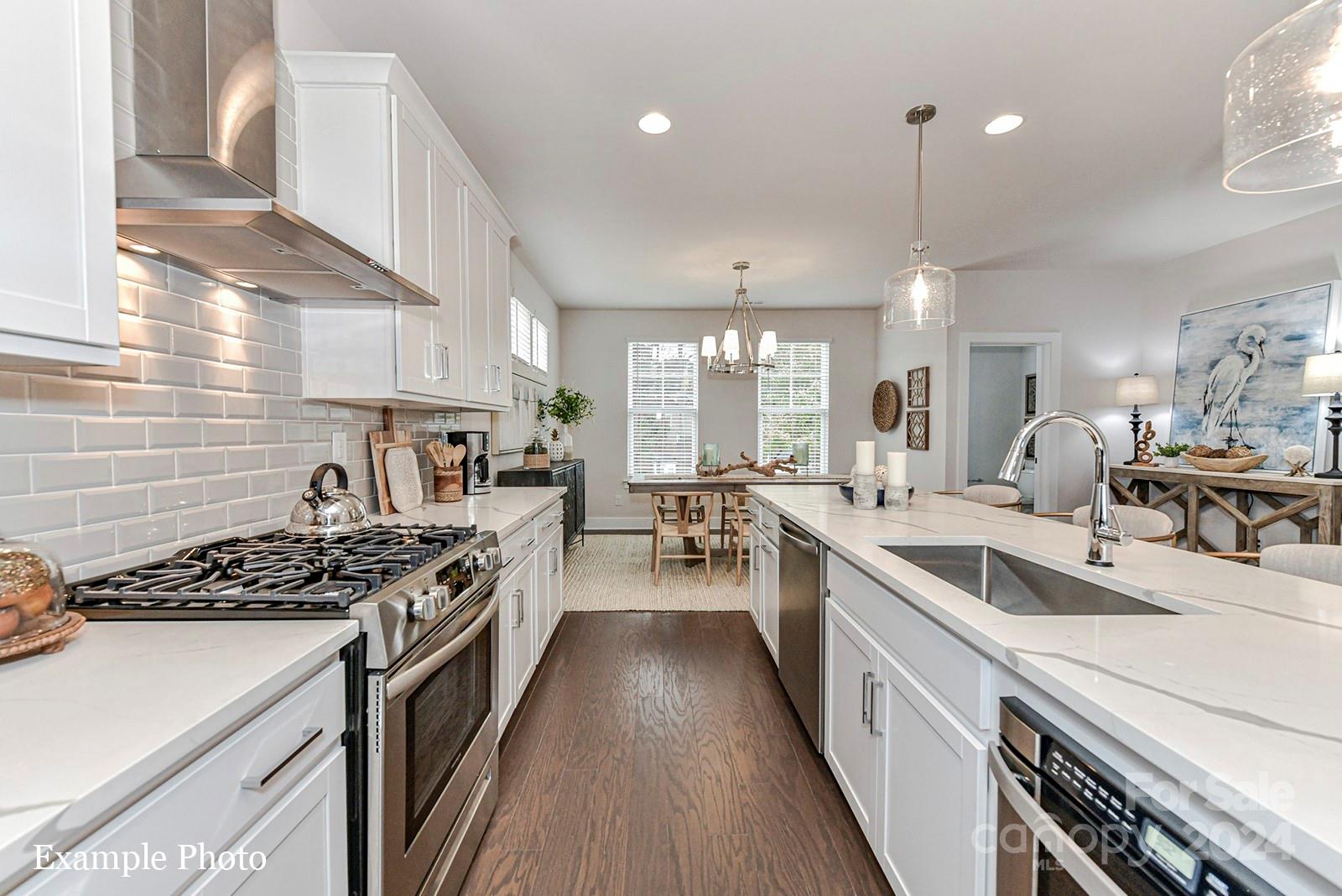 a kitchen with a sink a stove and chairs